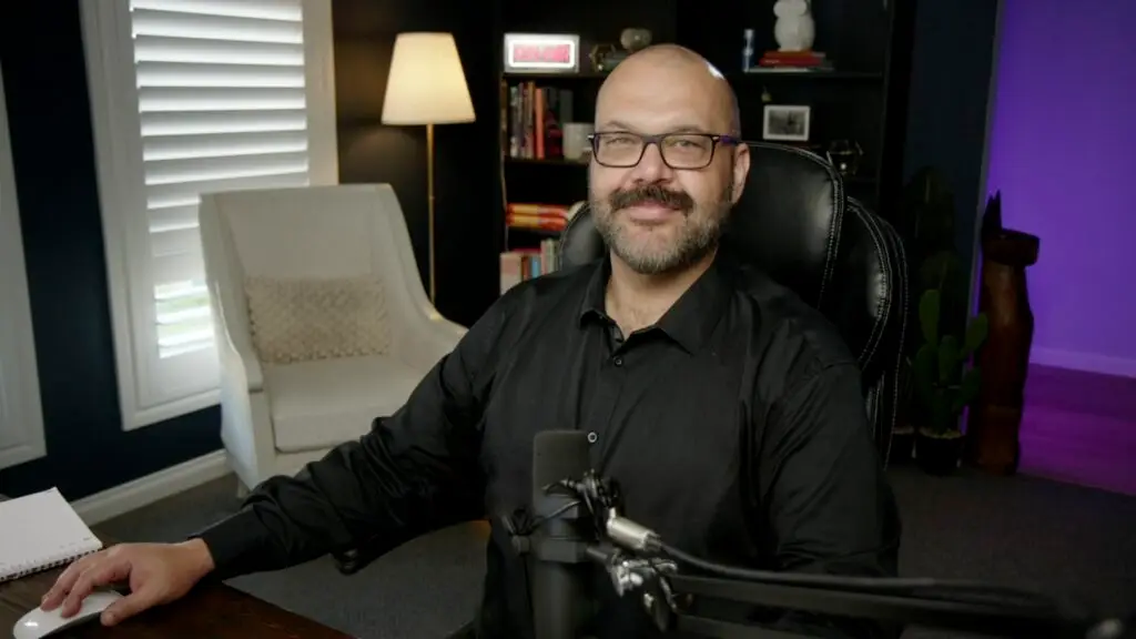 Nathan Little at his desk with a podcast microphone.